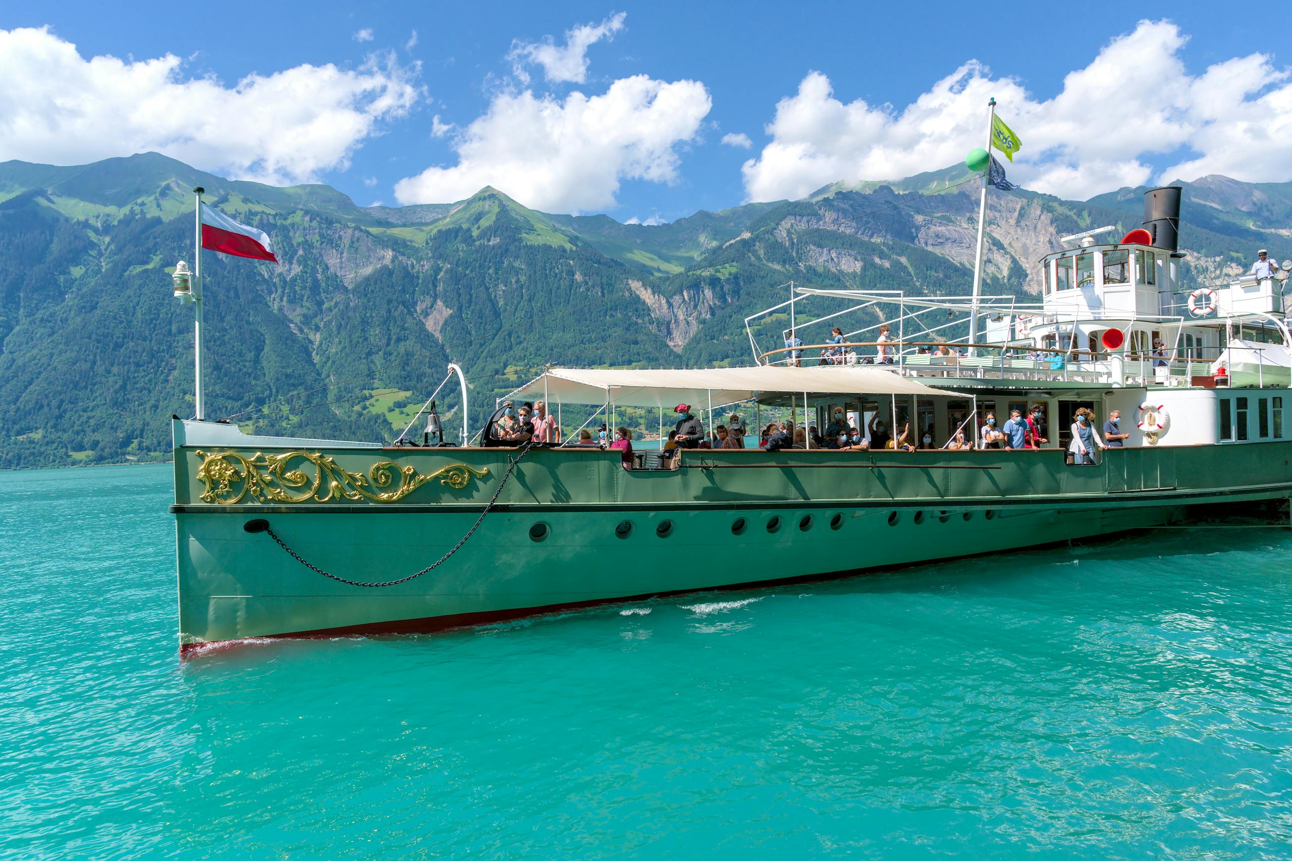 Explore a picturesque boat cruise on Lake Brienz, surrounded by Swiss Alps and clear skies.